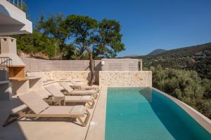 une piscine avec des chaises longues et une piscine dans l'établissement Villa Oliva -Seaside Charm with Village at Your Doorstep, à Sývota 13 autres photos