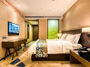 a bedroom with a bed and a desk and a computer at Zmax Hotel·Harbin Bingxue Big World in Harbin +134 photos