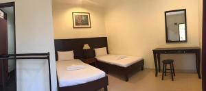 Perhentian Tivoli Inn في Kampong Pasir Panjang: غرفة بسريرين ومكتب ومرآة +34 صورة