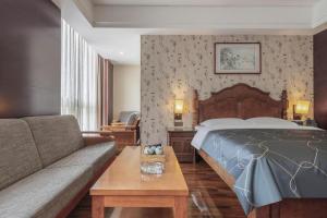 北京Chonpines Hotel Beijing Daxing Airport Caoqiao Metro Station的配有床和沙发的酒店房间