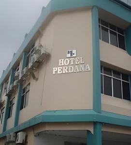 a building with a sign on the side of it at Hotel Perdana in Lawas