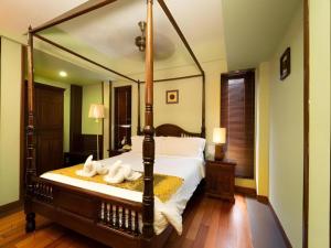 Un dormitorio con una gran cama con dosel y toallas encima. en Anggun Boutique Hotel, en Kuala Lumpur 208 fotos más