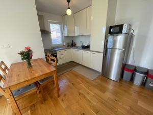 a kitchen with a wooden table and a refrigerator at Apartman Damir in Malinska