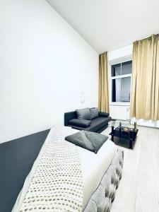 a bedroom with a large bed and a couch at Modren & Stylish 1BR Apartment in the heart of Vienna in Vienna