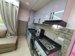 a small kitchen with a stove and a microwave at Petit Appartement Formidable a Imi Ouaddar in Agadir nʼ Aït Sa