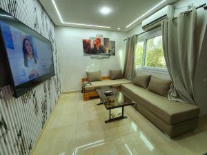 a living room with a couch and a flat screen tv at Petit Appartement Formidable a Imi Ouaddar in Agadir nʼ Aït Sa