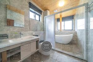 a bathroom with a tub and a sink and a shower at Lanyang Beach Villa in Wujie