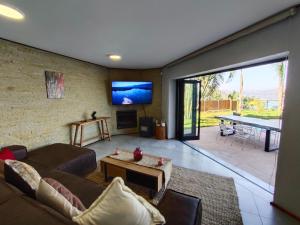 a living room with a couch and a tv at Letamo View - 5 bedroom house in Hartbeespoort