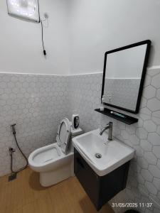 a bathroom with a toilet and a sink and a mirror at Supa Dupa Homestay Merbok 2 in Kampong Merbok +7 photos