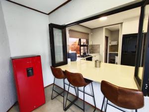 a kitchen with a red refrigerator and a table and chairs at Letamo View - 5 bedroom house in Hartbeespoort