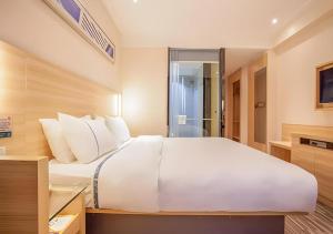 a large white bed in a hotel room at City Comfort Inn Nanning Jinhu Plaza Langxi Metro Station Exhibition in Nanning +161 photos
