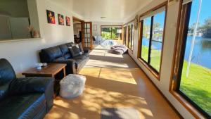 a living room with leather furniture and a view of the water at A Slice Of Paradise in Sussex Inlet