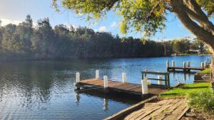 a dock on a lake with a bench on it at A Slice Of Paradise in Sussex Inlet