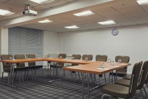 una sala de conferencias con mesas y sillas de madera en Holiday Inn Newcastle Gosforth Park by IHG, en Newcastle