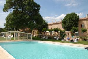 a large swimming pool in front of a house at Domaine Les Terres de Saint-Hilaire in Ollières