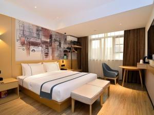 a hotel room with a large bed and a chair at City Comfort Inn Kunming Nanping Pedestrian Street Wangfujing in Kunming