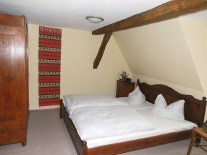 ein Schlafzimmer mit einem Bett mit weißen Laken in der Unterkunft Ferienwohnungen im Harz in Stolberg i. Harz