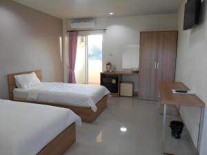 a hotel room with two beds and a desk and a kitchen at Bumnsaya Place in Ban Nong Samet