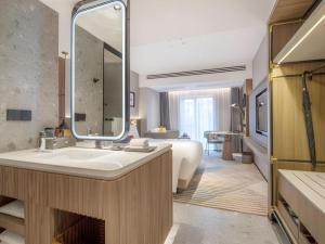 a bathroom with a tub and a sink and a mirror at Aden Select Shenzhen Taizi in Shenzhen +88 photos