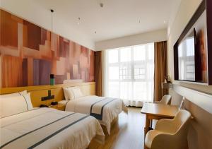 une chambre d'hôtel avec deux lits et un bureau dans l'établissement City Comfort Inn Baise Jinxiuguoji, à Baise