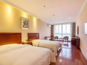 徐州GreenTree Inn Xuzhou High Speed Railway Zhangqian Square Business Hotel的有两张床和一张桌子的酒店房间