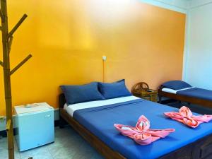 a bedroom with a bed with two pink flowers on it at VaoVao Hotel in Nosy Be