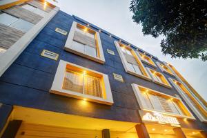 a blue building with windows and lights on it at Super Townhouse Pine Tree in Indore