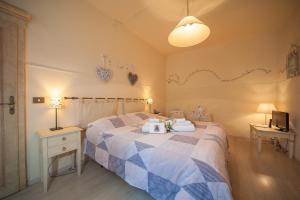 ein Schlafzimmer mit einem Bett, 2 Tischen und einem TV in der Unterkunft Albergo Etruria in Volterra