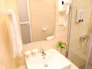 a bathroom with a sink and a mirror at GreenTree Inn JiangSu DingShu Twon JieFang(E) Road Express Hotel in Zhoushu