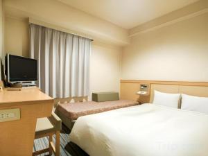 a hotel room with two beds and a television at Premier Hotel Cabin Matsumoto in Matsumoto