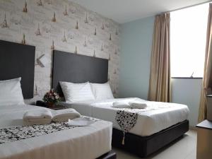 two beds in a hotel room with white walls at City View Hotel At KLIA & KLIA2 in Kuala Lumpur +64 photos