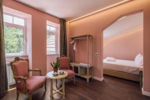 een kamer met een bed en twee stoelen en een tafel bij Palacete do Guerreiro SPA & Country House in Oliveira do Hospital +149 foto's