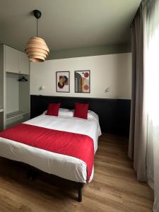 a bedroom with a large bed with a red blanket at Foresteria 33 in Ghedi