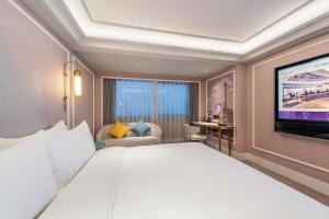 a hotel room with a large bed and a flat screen tv at Mercure Hefei Huaihe Road in Hefei
