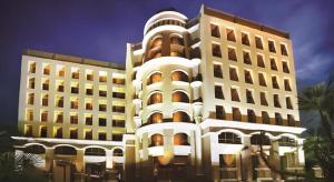 a large white building next to two tall buildings at Maleewana Hotel & Resort in Bang Yai