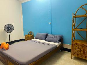 a bedroom with a bed and a blue wall at VaoVao Hotel in Nosy Be