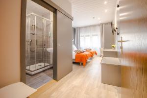 Un baño con ducha y una cama en una habitación. en Mandarina Hotel Luxembourg Strassen, en Luxemburgo