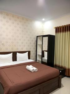 a bedroom with a bed with a towel on it at Prime Adisucipto Hotel in Kalasan
