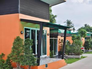 an orange and black building with trees in front of it at Nawamit Home Garden in Nakhon Si Thammarat