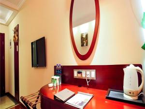 a room with a desk with a mirror on the wall at GreenTree Inn Anhui Suzhou Baima Mall Express Hotel in Suzhou +137 photos