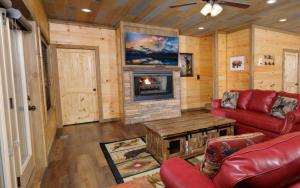 a living room with a red couch and a fireplace at Bigger Bear Views Lodge in Gatlinburg