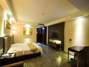 a hotel room with a bed and a desk and a television at GreenTree Inn Jiangxi Yingtan Jiaotong Road Central Square Business Hotel in Yingtan +225 photos