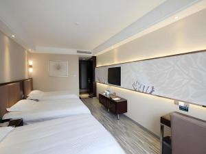 a hotel room with two beds and a flat screen tv at GreenTree Inn Jiangxi Yingtan Jiaotong Road Central Square Business Hotel in Yingtan