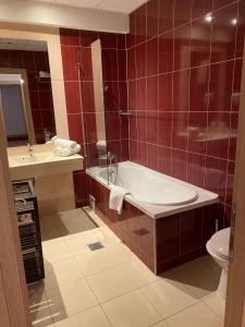 a bathroom with a tub and a sink and a toilet at Red apartament in Bucharest