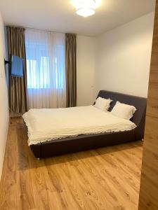 a bedroom with a large bed in front of a window at Red apartament in Bucharest
