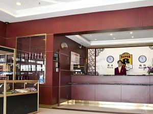 a woman is standing behind a counter in a store at Super 8 Hotel Shanghai Songjiang University Town Branch in Shanghai