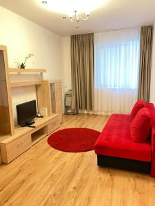 a living room with a red couch and a television at Red apartament in Bucharest