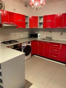 a kitchen with red cabinets and a washing machine at Red apartament in Bucharest