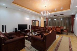 a living room with couches and a television and a table at Marys Family Guest House in Yerevan