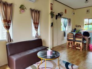 a living room with a couch and a table at บ้านริมน้ำอุ่นรัก in Ban Na Kai +8 photos